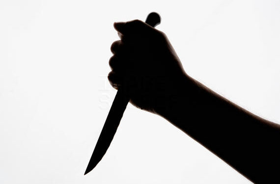 A silhouette of a hand holding a knife