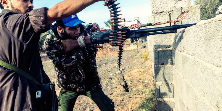 On the front line of Al Swani during the clashes, a fighter of Brigade 610 (GNA) fires with his machine-gun while his comrade points his finger towards the enemy. Since April, the Libyan National Army (LNA) led by Khalifa Haftar is attempting to take control of Tripoli defended by the forces of UN-backed recognised Government of National Accord of Fayez el-Sarraj (GNA). Libya, outskirts of Tripoli, December 6, 2019. 
Sur la ligne de front de Al Swani pendant les affrontements, un combattant de la brigade 610 (GAN) tire avec sa mitraille alors que son camarade pointe du doigt l'ennemi. Depuis avril, l'armee nationale Libyenne (LNA) dirigee par Khalifa Haftar essaie de prendre le control de Tripoli defendu par les forces du gouvernement d'accord national de Fayez al-Sarraj, soutenu par l'onu (GAN). Libye, banlieue de Tripoli, 6 decembre 2019.NO USE FRANCE