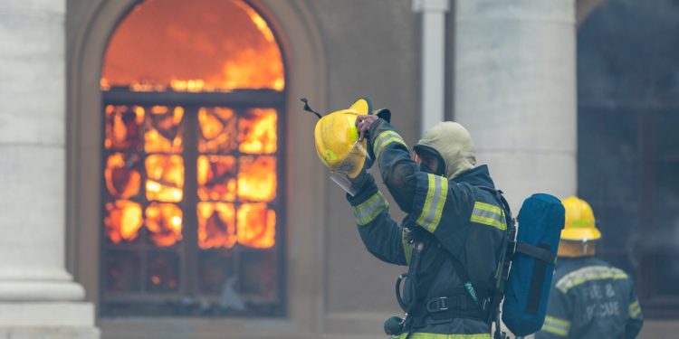 epa09143901 A fire fighter prepares to battle a blaze that destroyed the nearly 200-year-old Jagger Library on the University of Cape Town (UCT) campus in Cape Town, South Africa, 18 April 2021. A bushfire on the slopes of the world heritage site Table Mountain National Park raged out of control in strong winds and caused extensive damage to the University of Cape Town and many buildings around the nearly 200-year-old University founded in 1829. All students were evacuated from campus and several fire fighters were injured battling the blaze on the slopes of Table Mountain.  EPA-EFE/NIC BOTHMA