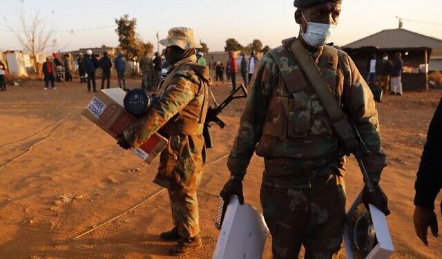 Members of the South African Defence Force (SANDF) hold stolen items retrieved during a raid after six days of looting in South-Africa left scores of dead and battered the economy, in Mamelodi, east of Pretoria, on July 14, 2021. - Seventy-two people have died and more than 1,200 people have been arrested, according to official figures, since ex-president Jacob Zuma began a 15-month jail term for contempt, sparking protests that swiftly turned violent. (Photo by Phill Magakoe / AFP)