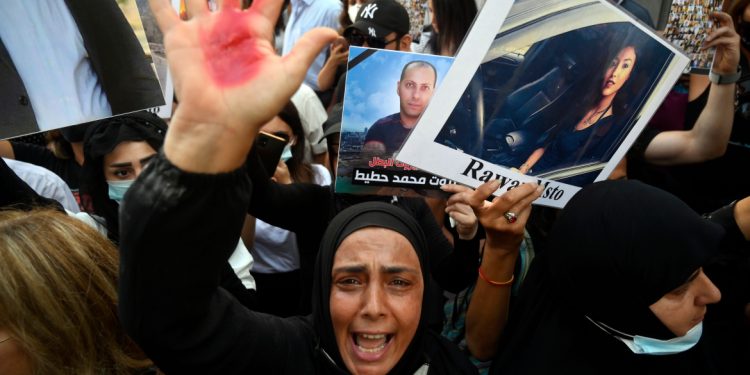 epa09342958 A mother of a victim of the 04 August Beirut port explosion shouts slogans as she shows her hand covered with red paint, during a protest outside of the Lebanese Interior Minister Mohammed Fahmi house in Beirut, Lebanon, 13 July 2021. Families of some victims of 04 August 2020 Beirut port explosion gathered outside of the Lebanese Interior Minister Mohammed Fahmi house as they are asking for lift immunity of three MPs and senior politicians and former and current security chiefs in the case to be investigated in connection to the Beirut port explosion. A massive blast on 04 August 2020 rocked Beirut's port in which at least 200 people were killed and more than 6,000 injured, believed to have been caused by an estimated 2,750 tons of ammonium nitrate stored in a warehouse, devastated the port area of Beirut and several parts of the city.  EPA-EFE/WAEL HAMZEH