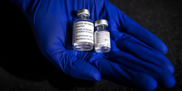 A staff member holds the first ever vials to be administered of the Oxford Astrazeneca (left) and Pfizer-BioNTech vaccines which will form part of a new COVID-19 exhibition at the Science Museum in London when it reopens after lockdown. Picture date: Thursday March 11, 2021. (Photo by Victoria Jones/PA Images via Getty Images)