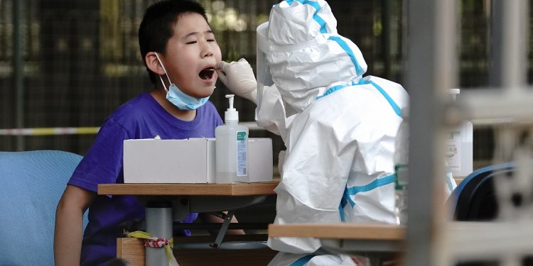 BEIJING, CHINA - JUNE 30:  A medical worker wearing a protective suit takes a swap at a temporary COVID-19 testing site on June 30, 2020 in Beijing, China. As of today, the nucleic acid testing completed number of people in Beijing has reached 9 million. The authorities in Beijing have begun an operation to contain a potential second wave of coronavirus.  (Photo by Lintao Zhang/Getty Images)