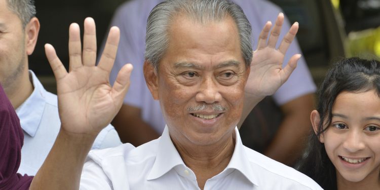 Politician Muhyiddin Yassin, center, waves to media after outside his house after he being appointed as the new prime minister in Kuala Lumpur, Malaysia, Saturday, Feb. 29, 2020. Malaysia's king has appointed seasoned politician Muhyiddin Yassin as the new prime minister, trumping Mahathir Mohamad's bid to return to power after a week of political turmoil that followed his resignation as prime minister. (AP Photo/John Shen Lee)