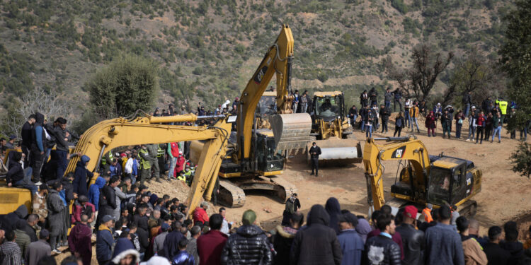 Residents watch civil defense workers and local authorities attempting to rescue a 5 year old boy who fell into a hole near the town of Bab Berred near Chefchaouen, Friday, Feb. 4, 2022 in Ighran. A third day of efforts to rescue a 5-year-old boy who fell into a well in northern Morocco was halted for a time on Friday following concerns about ground stability, fueling despair among those hoping to reach him. The boy, identified as Rayan, fell into a 32-meter (105-feet) deep well located outside his home in the northern village of Ighran in Morocco's Chefchaouen province on Tuesday evening.(AP Photo/Mosa'ab Elshamy)