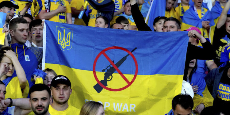 Ukraine fans hold up an anti-war banner at the end of the World Cup 2022 qualifying play-off soccer match between Scotland and Ukraine at Hampden Park stadium in Glasgow, Scotland, Wednesday, June 1, 2022. (Andrew Milligan/PA via AP)