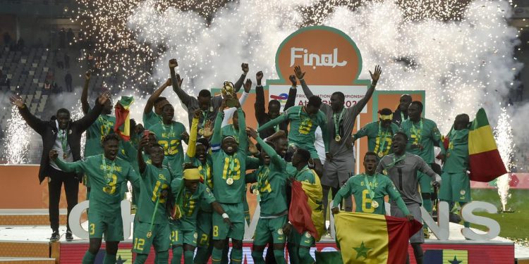 Senegal’s players celebrate with the trophy on the podium after winning CHAN final against Algeria at the Nelson Mandela stadium in Algiers on Saturday. PHOTO: AFP