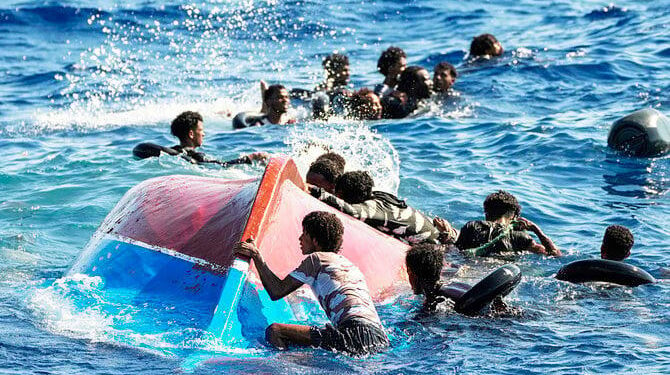 Migrants swim next to their overturned wooden boat during a rescue operation. (File/AP)