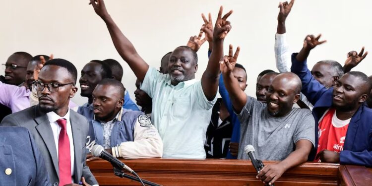 Ugandan opposition supporters gesture in the dock where they were charged with terrorism-related offences, after they were deported from neighbouring Kenya, where they had traveled to attend a training course in Kisumu, at the Nakawa Chief Magistrates court in Kampala, Uganda July 29, 2024. REUTERS/Abubaker Lubowa/File Photo