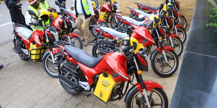 (230706) -- NAIROBI, July 6, 2023 (Xinhua) -- People look at the electric motorbikes during the launch of an e-bike project in Nairobi, capital of Kenya, on July 5, 2023. Kenya on Wednesday launched a project to provide financial support for electric motorbike taxi riders to reduce carbon emission of the transport sector in the captial city of Nairobi. (Photo by Joy Nabukewa/Xinhua)