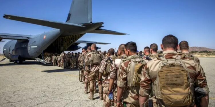 French soldiers stand in line as they board a military plane following their departure from Abeche military base as part of an on ongoing withdrawal of French Forces in Abeche on January 11, 2025.